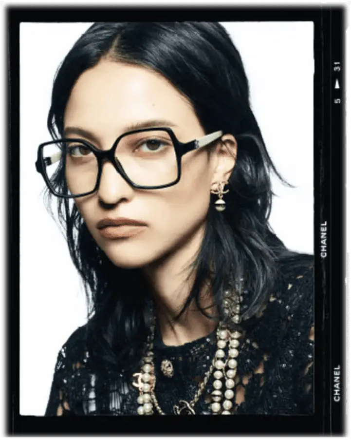 Frau in Brille mit Schmuck.