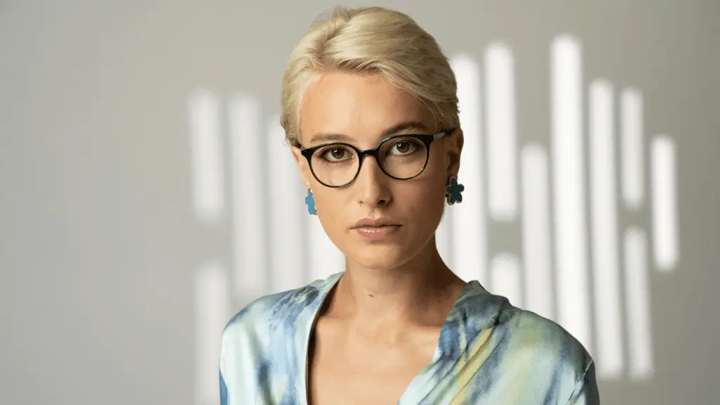 Frau mit Colibris Brille und stylischen Ohrringen.
