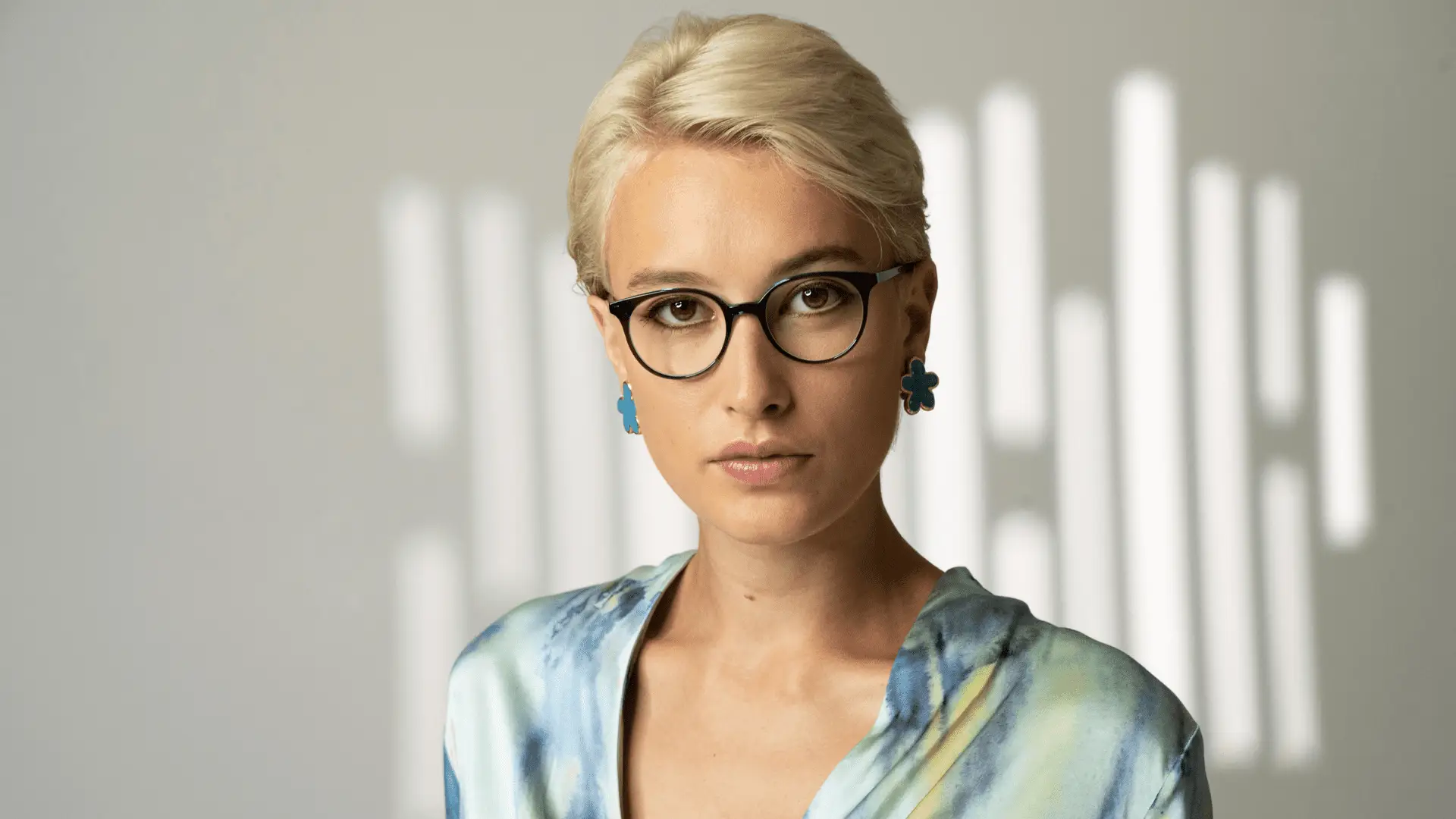 Frau mit Colibris Brille und stylischen Ohrringen.