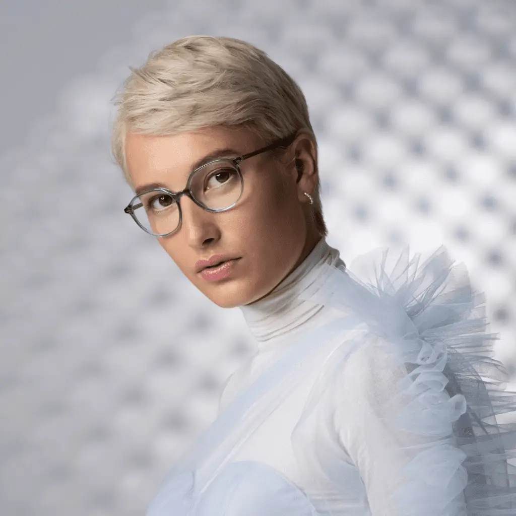 Frau mit kurzen blonden Haaren und Colibris Brille.