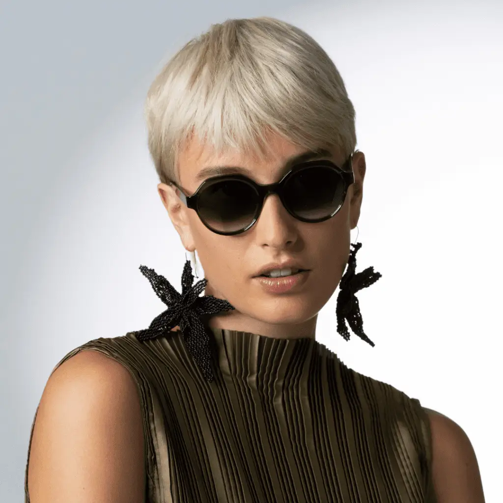 Frau mit Colibris Sonnenbrille und modischen Ohrringen.