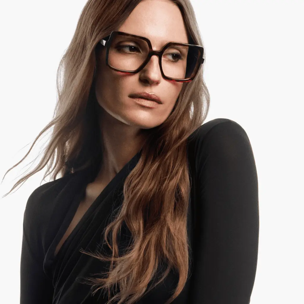 Frau mit Brille und schwarzem Oberteil.