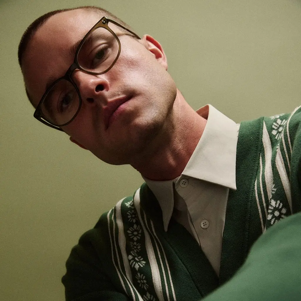 Mann mit Brille von GLCO Bentley und grünem Pullover.