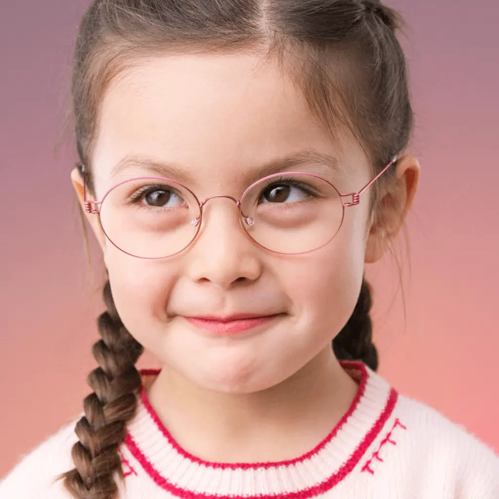 Mädchen mit Lindberg Kinderbrille und Zöpfen lächelt.
