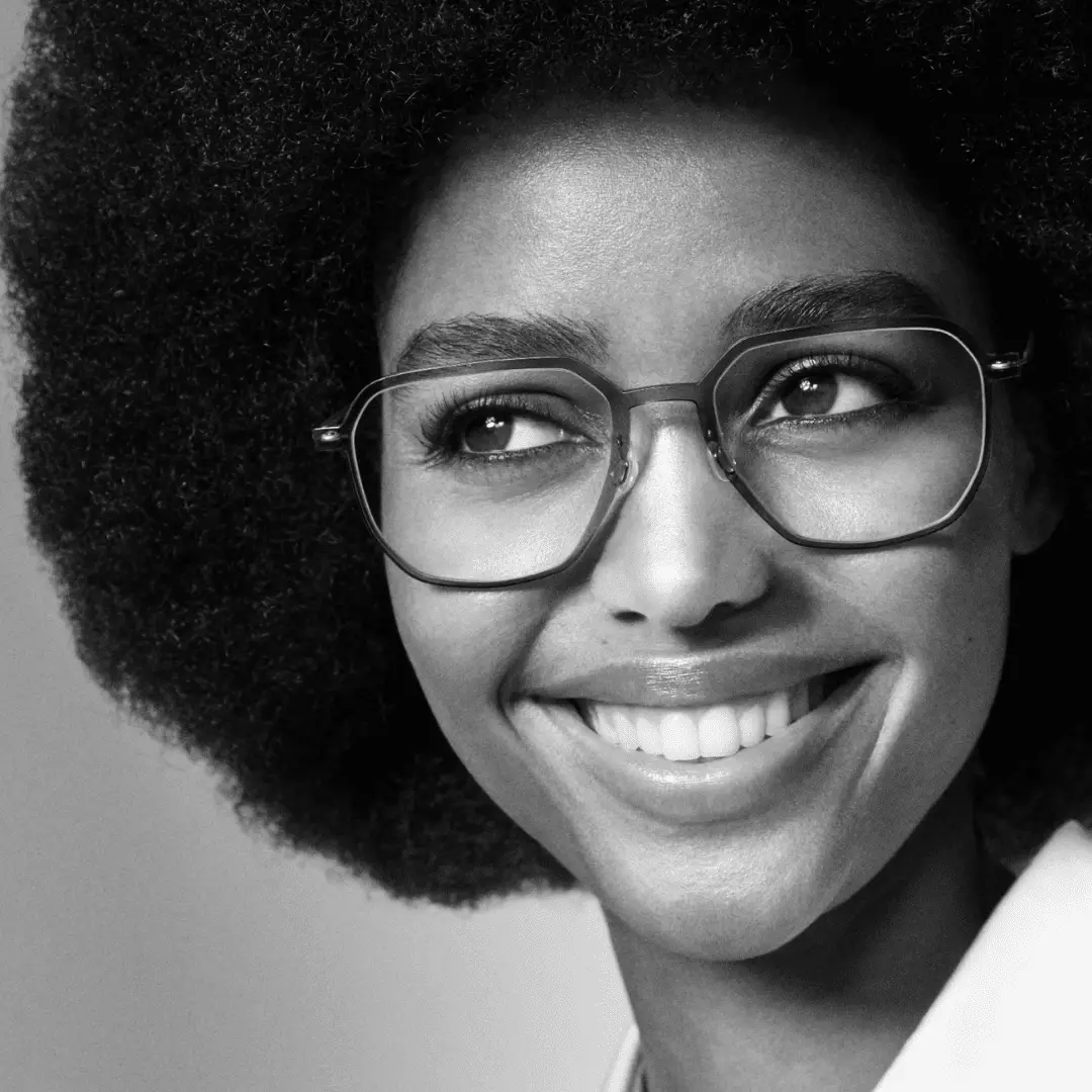 Frau mit Brille von Lindberg lächelt, Schwarz-Weiß-Foto.